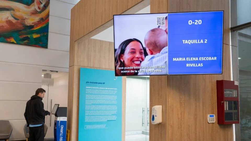 Écran d'appel de tickets combiné avec un affichage dynamique diffusant une vidéo d'entreprise dans une salle d'attente